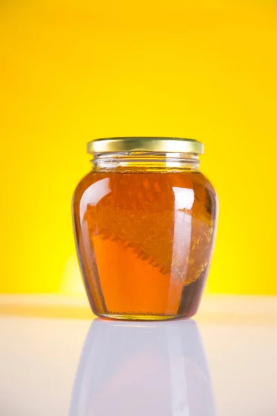 Medu ve sklenici s medem naběračka na dřevěné pozadí — Stock fotografie