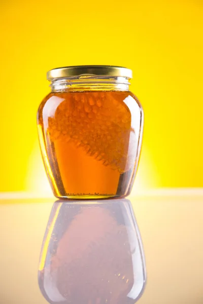 Miel en tarro con cazo de miel sobre fondo de madera — Foto de Stock