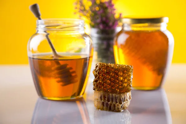 Honey in jar with honey dipper on wooden background — Stock Photo, Image