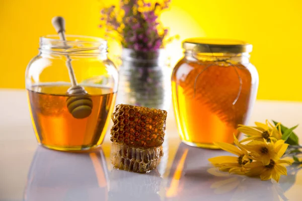 Honey in jar with honey dipper on wooden background — Stock Photo, Image