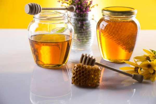 Miel en tarro con cazo de miel sobre fondo de madera — Foto de Stock