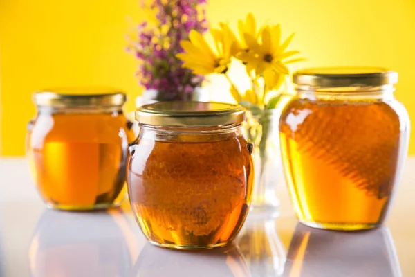 Honey in jar with honey dipper on wooden background — Stock Photo, Image