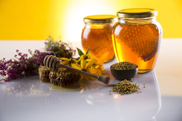 Мед в банке с медом ковша на деревянном фоне
