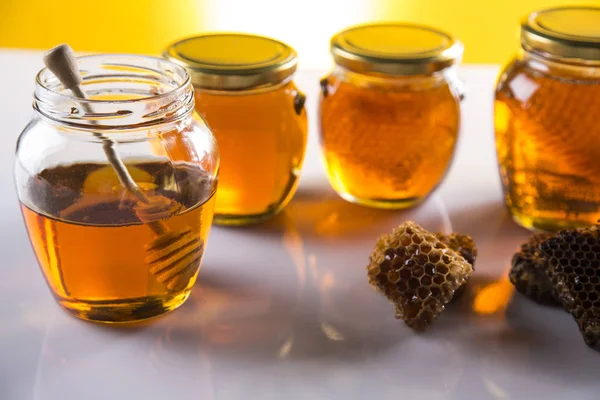 Μέλι σε βάζο με μέλι κουτάλα σε φόντο ξύλινη — Φωτογραφία Αρχείου