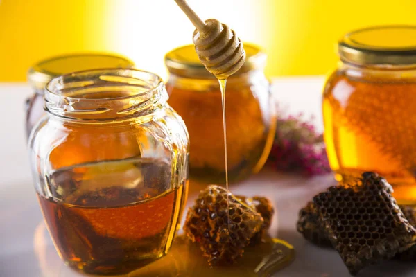 Honey in jar with honey dipper on wooden background — Stock Photo, Image