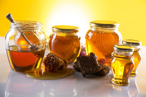 Honey in jar with honey dipper on wooden background