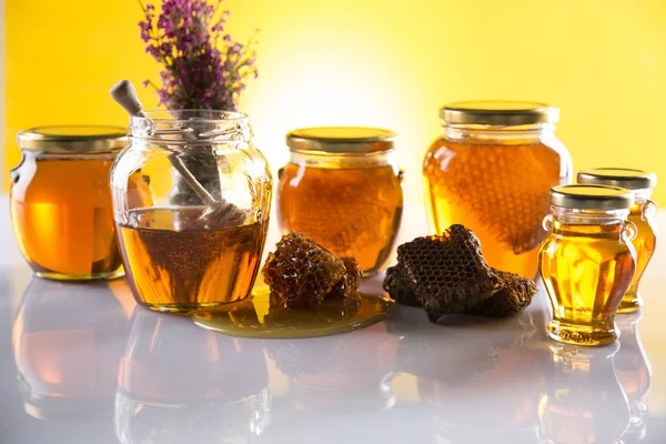 Honey in jar with honey dipper on wooden background — Stock Photo, Image