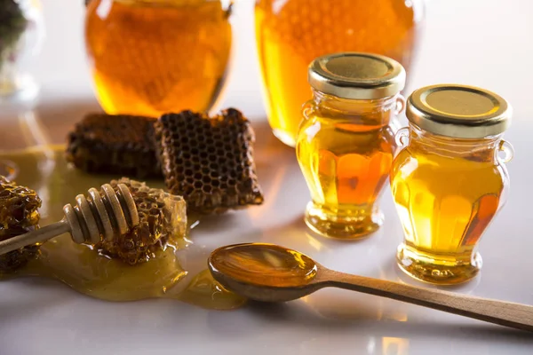 Honey in jar with honey dipper on wooden background — Stock Photo, Image