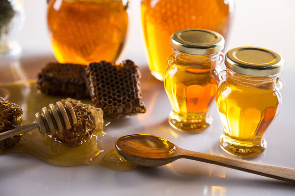 Мед в банке с медом ковша на деревянном фоне
