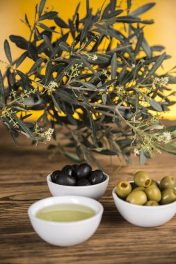 Ahşap tabonda zeytinyağı, zeytin ağacı ve yeşil ve siyah zeytin