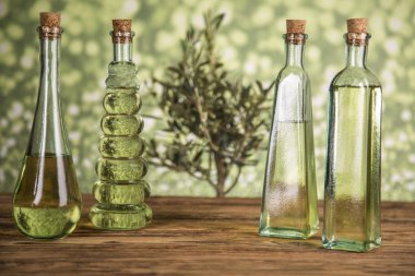 Zeytin ağacı ve yağ ile şişeler, ahşap bir masada zeytin