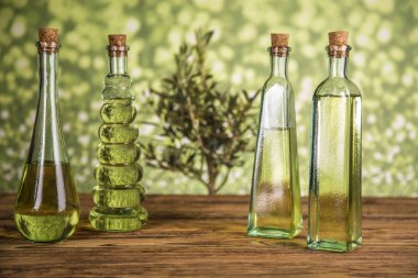 Zeytin ağacı ve yağ ile şişeler, ahşap bir masada zeytin