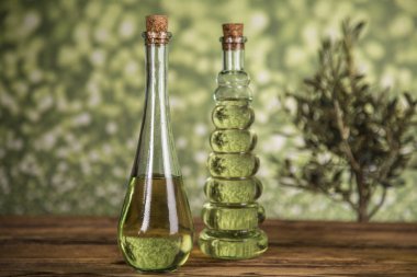 Zeytin ağacı ve yağ ile şişeler, ahşap bir masada zeytin