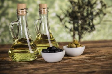 Ahşap tabonda zeytinyağı, zeytin ağacı ve yeşil ve siyah zeytin