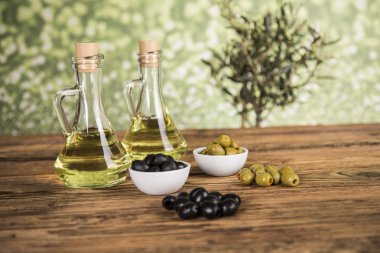 Ahşap tabonda zeytinyağı, zeytin ağacı ve yeşil ve siyah zeytin