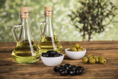 Ahşap tabonda zeytinyağı, zeytin ağacı ve yeşil ve siyah zeytin