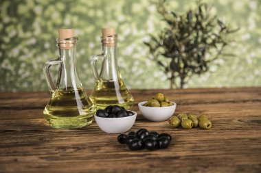 Ahşap tabonda zeytinyağı, zeytin ağacı ve yeşil ve siyah zeytin