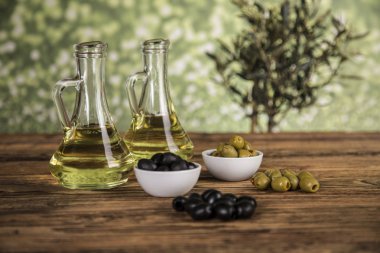 Ahşap tabonda zeytinyağı, zeytin ağacı ve yeşil ve siyah zeytin