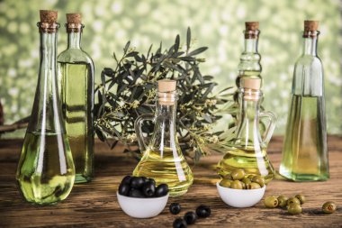 Ahşap tabonda zeytinyağı, zeytin ağacı ve yeşil ve siyah zeytin