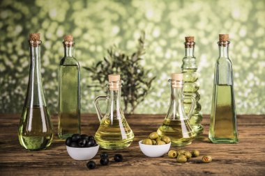 Ahşap tabonda zeytinyağı, zeytin ağacı ve yeşil ve siyah zeytin