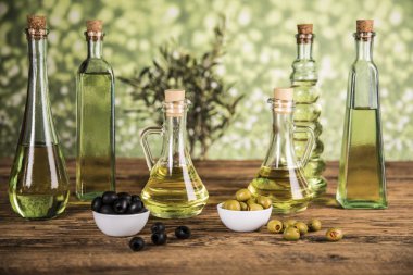 Ahşap tabonda zeytinyağı, zeytin ağacı ve yeşil ve siyah zeytin
