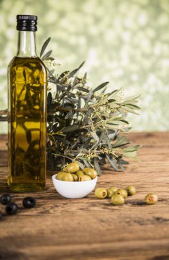 Ahşap tabonda zeytinyağı, zeytin ağacı ve yeşil ve siyah zeytin