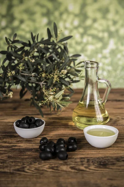 Olivový olej a olivovník, černé olivy a láhve s olivovým olejem — Stock fotografie
