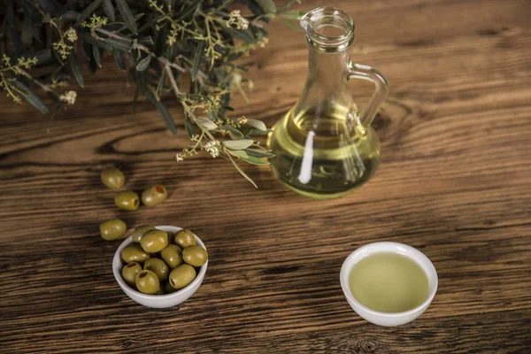 Olive oil, olive tree and green olives, bottles of olive oil