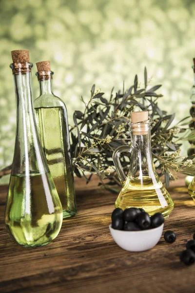 Olive oil, olive tree and green and black olives on a wooden tab — Stock Photo, Image