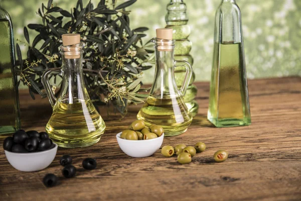 Olive oil, olive tree and green and black olives on a wooden tab — Stock Photo, Image