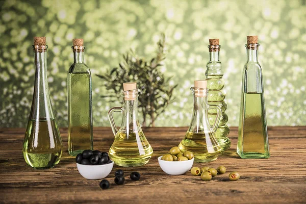 Olio d'oliva, ulivo e olive verdi e nere su una scheda di legno — Foto Stock