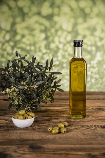 Olive oil, olive tree and green olives, bottles of olive oil.