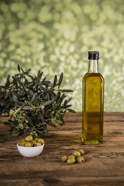 Olive oil, olive tree and green olives, bottles of olive oil.
