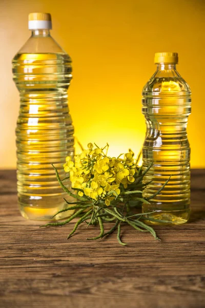 テーブルの上のボトルに菜種の花や菜種油 — ストック写真