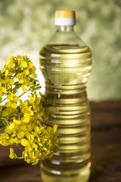 テーブルの上のボトルに菜種の花や菜種油 — ストック写真