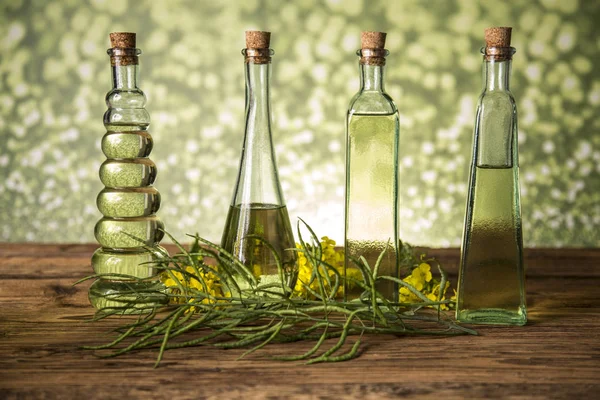Semena a řepice v lahvích a karafích s řepným olejem — Stock fotografie