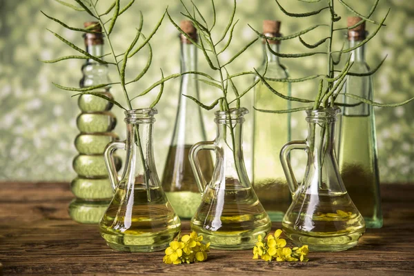 Semi e fiori di colza in bottiglie e caraffe con olio di colza — Foto Stock