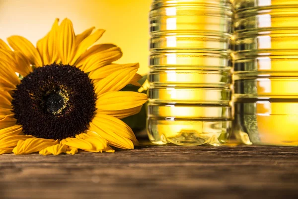 Zonnebloemolie in een fles, zonnebloem bloem op een houten tafel — Stockfoto