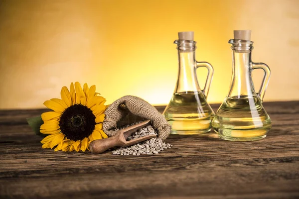Slunečnicový olej v lahvích a slunečnicových květech a slunečnicovém se — Stock fotografie
