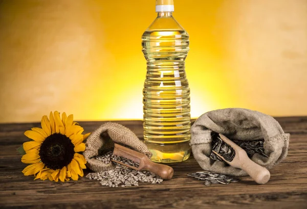 Aceite de girasol en una botella y semillas de girasol y girasol — Foto de Stock