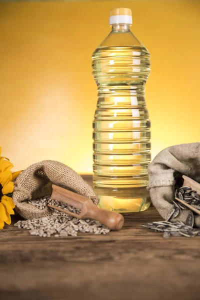 Aceite de girasol en una botella y semillas de girasol y girasol — Foto de Stock
