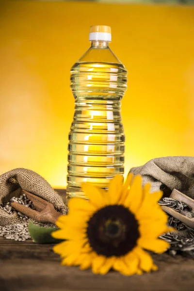 Aceite de girasol en una botella y semillas de girasol y girasol — Foto de Stock