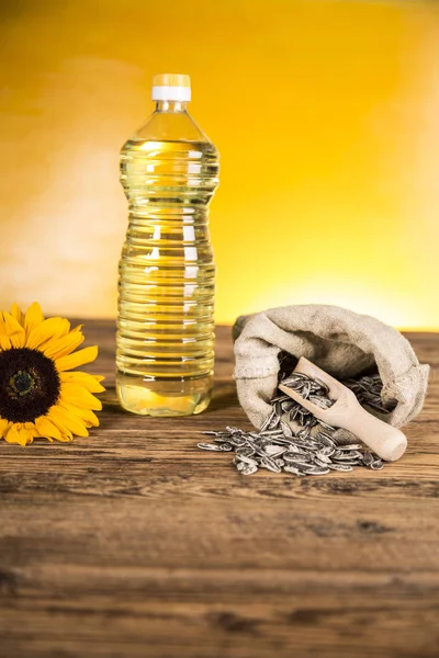 Aceite de girasol en una botella y semillas de girasol y girasol — Foto de Stock