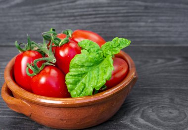 Koyu bir arka plan üzerinde bir tabakta taze domates