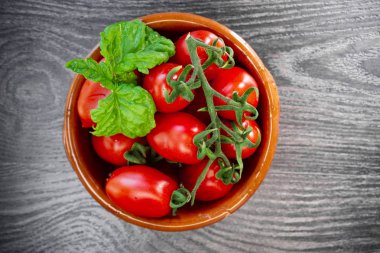 Koyu bir arka plan üzerinde bir tabakta taze domates