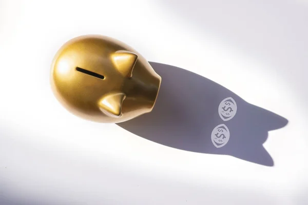 Top view gold piggy bank on white background with shadows in the eyes is money icon. concept savings