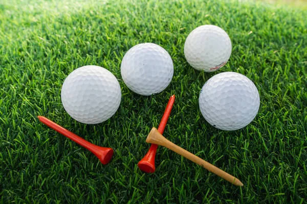 close up the golf ball and tee pegs on the green background