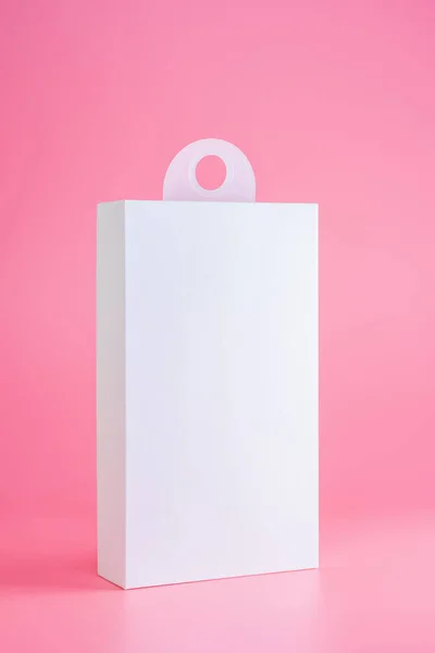 ホワイト段ボールパッケージモックアップはハンガーでピンクの背景に隔離されています — ストック写真