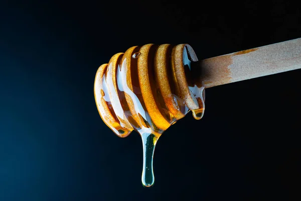 暗い背景にマクロ木製の蜂蜜のディップと蜂蜜 — ストック写真