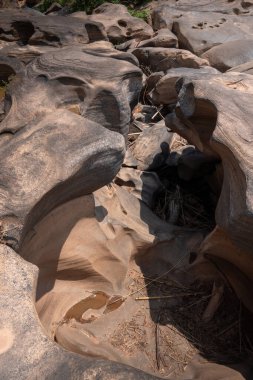 Engebeli, küçük ve büyük taş avlusu. Akıntıların oluşturduğu erozyon, çakıllar milyonlarca yıl boyunca küçük havzalarda dönerek aşınarak Phetchabun Eyaleti Tayland 'da çukurlar oluşturdu.